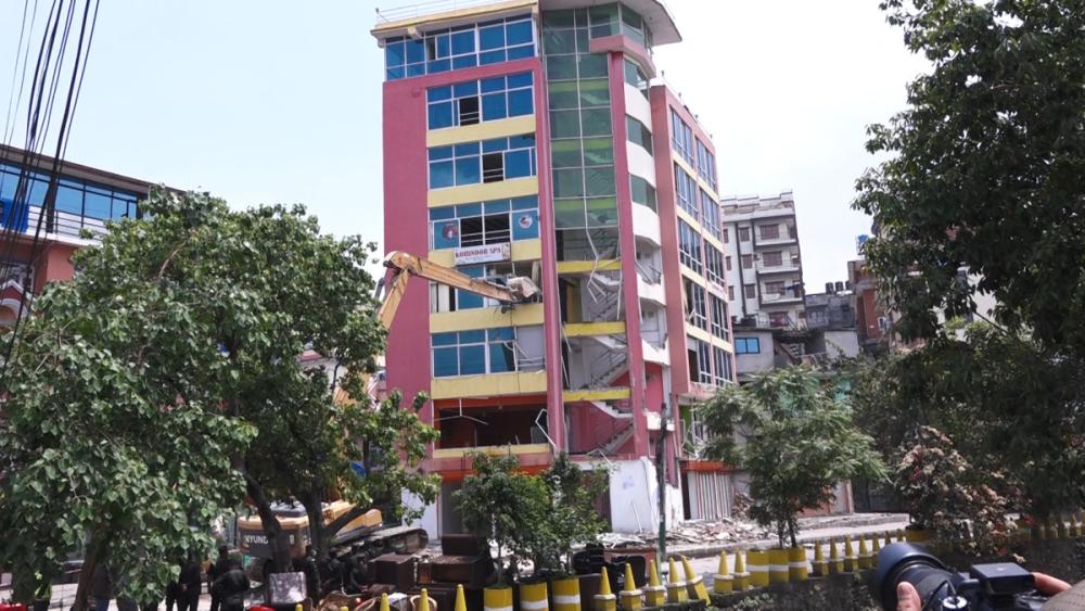 धोविखोलामा सडक मिचेर बनाइएको सात तले घरमा लगाइयो डोजर